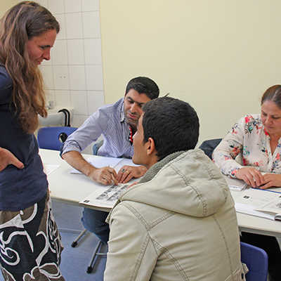 In der Flüchtlingsbetreuung arbeiten zu einem Großteil Frauen, hier links im Bild die Lehrerin Cordula Zimper bei einem Deutschkurs der VHS. Dort treffen sie auf Männer und Frauen aus dem arabischen Raum, die ganz andere Geschlechterbilder gewohnt sind. 