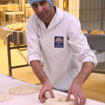 Ezat Khwaja aus Afghanistan bei seiner Arbeit in der Großbäckerei Biebelhausener Mühle. Bild: Bürgerservice Trier