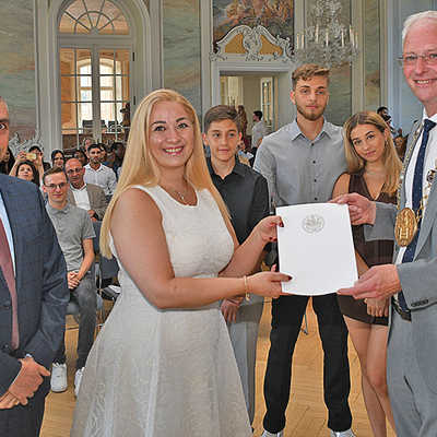 OB Wolfram Leibe überreicht die Einbürgerungsurkunde an Rana Ibrahim. Auch ihr Mann Wael Akari (l.) und die Kinder Zain, Subhi und Judy (hinten, v l.) sind jetzt Deutsche.