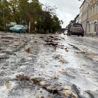 Blick in die Weberbach: Hier und in der Treviris, Ecke Moselstraße, sorgen zerdrückte Früchte des Lederhülsenbaums derzeit für Schaum auf der Straße. Er ist ungefährlich. Foto: Presseamt der Stadt Trier/StadtRaum
