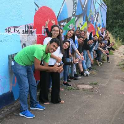 Die Jugendlichen und Organisatoren des Empowerment Workshops stehen vor dem Graffiti, das gemeinsam gestaltet wurde.