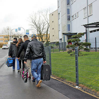 Sozialarbeiter (vorne) bringen zwei Brüder aus Afghanistan in eine städtische Sozialwohnung auf Mariahof, in der sie gemeinsam mit anderen Asylbewerbern untergebracht sind.